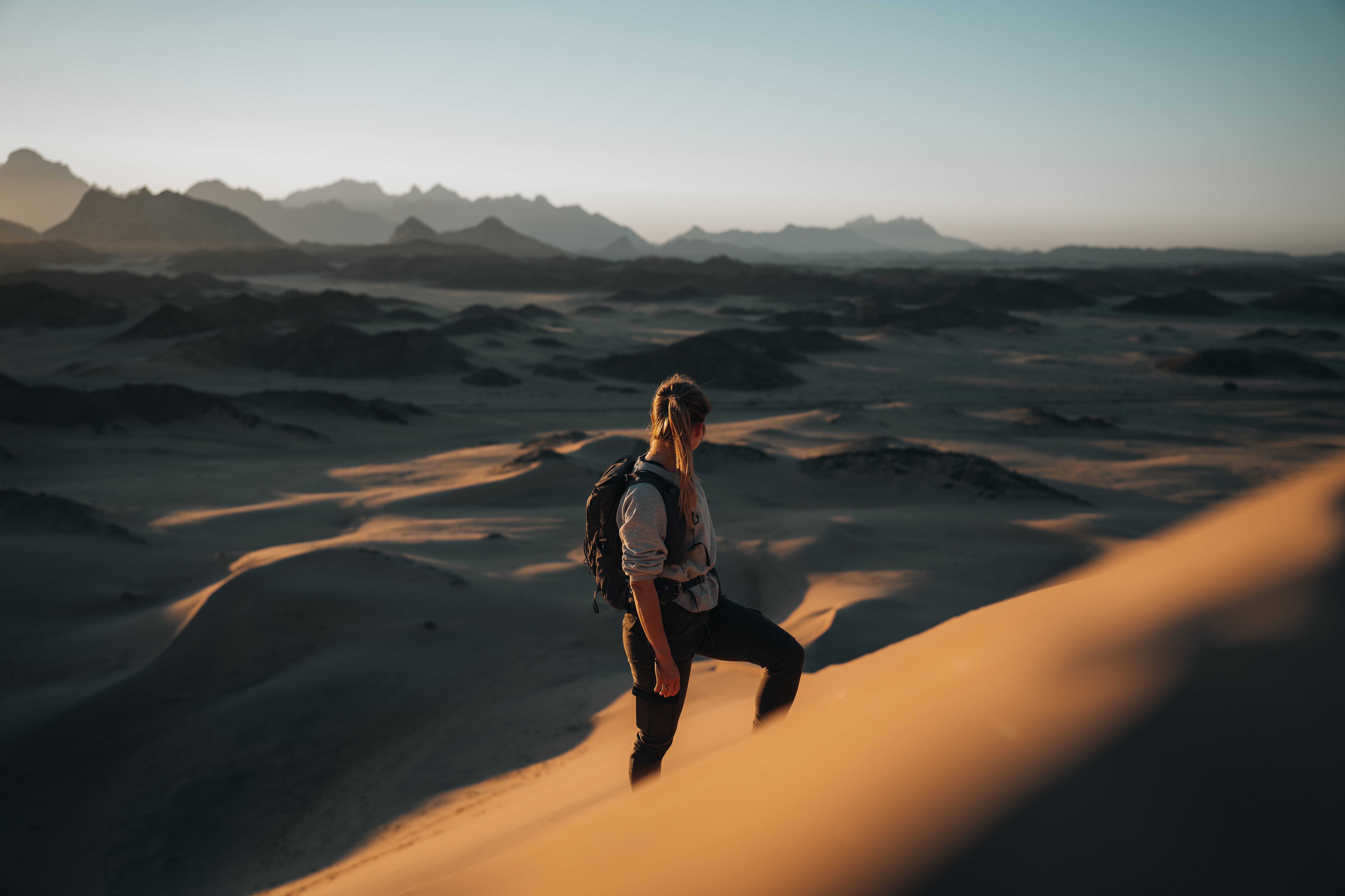 Woman with backpack in desert