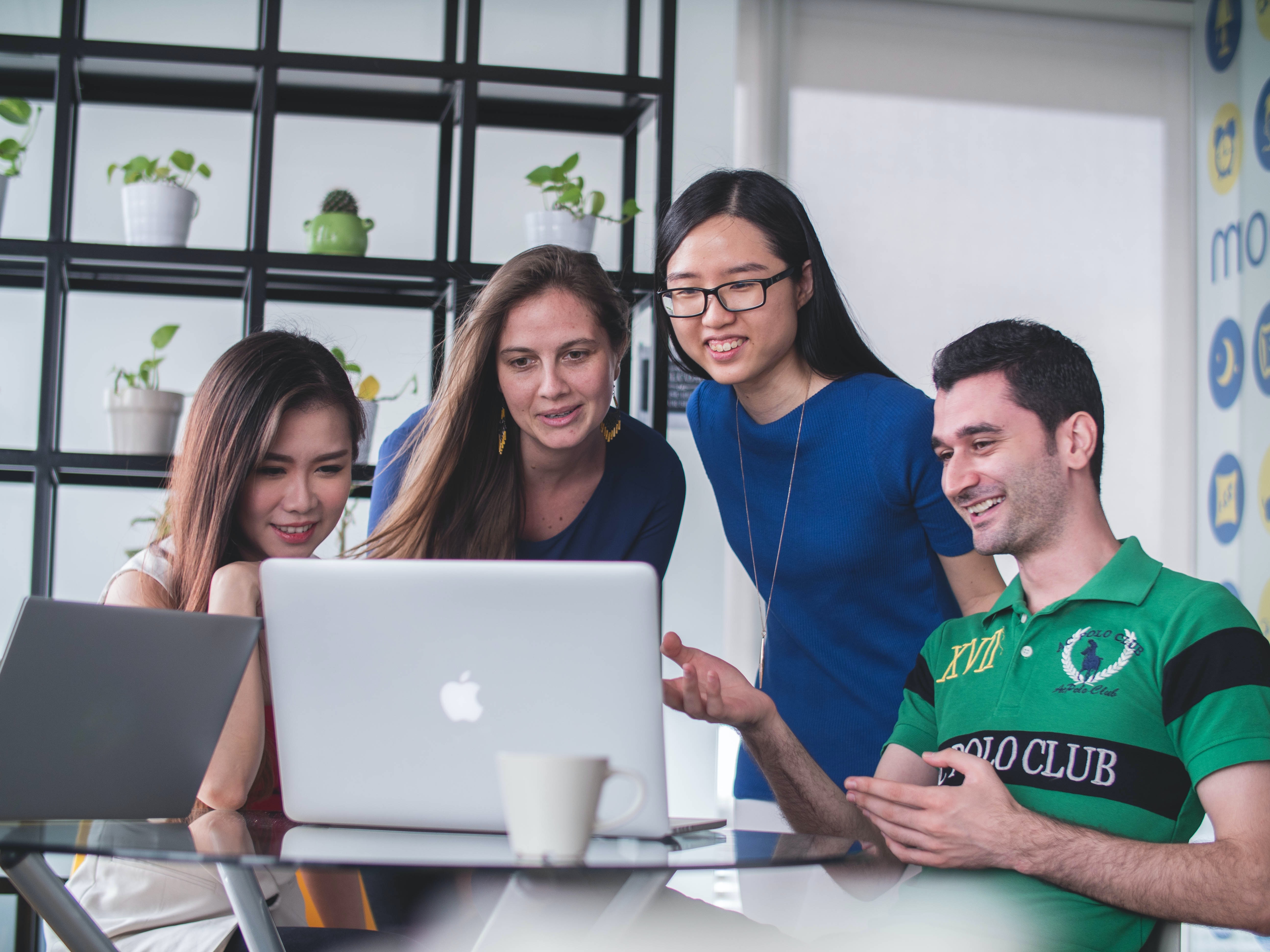 group of young people looking at laptop