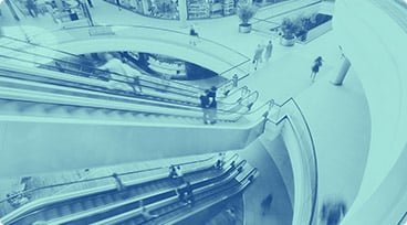 People on escalators in shopping mall