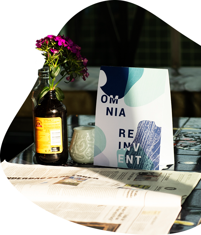 Omnia REINVENT agenda and flowers on table